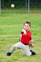 Child in uniform throwing baseball