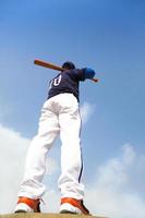jugador de béisbol con un bate con cielo azul foto