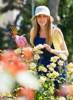 sonriente mujer joven en uniforme en jardinería