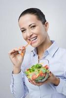 Cheerful woman eating salad photo