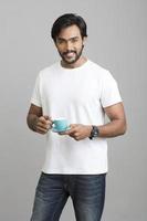 Cheerful Indian young with coffee photo