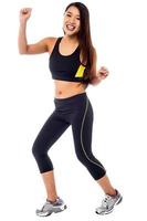 Cheerful fitness trainer dancing in joy photo