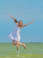 Cheerful girl  jumps over the sea