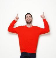 Cheerful young man pointing fingers up photo