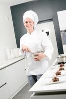 cheerful young woman professional pastry cook at work photo