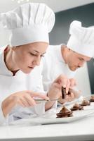 cheerful young woman professional pastry cook at work photo
