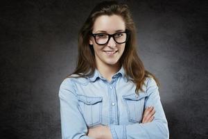 Cheerful young woman in jeans shirt and glasses photo
