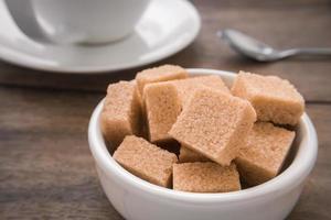 Brown sugar cubes in bowl and coffee cup photo