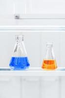 flasks with colorful liquids on a shelf photo