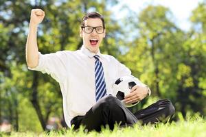 Young cheerful man holding a ball and gesturing happiness photo