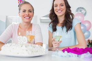 mujeres alegres con pastel de cumpleaños