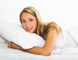 Cheerful woman lying on bed