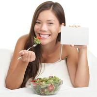 Woman Eating Salad showing copy space sign photo