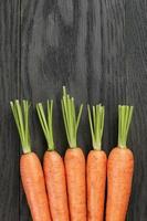 fresh carrots on old oak table with copy space photo