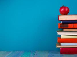 Stack of colorful books, grungy blue background, free copy space photo