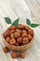 Whole hazelnuts without shell in wooden bowl with copy space photo