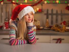 Adolescente mirando el espacio de la copia en Navidad decorado cocina foto