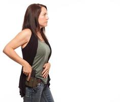 Woman about to draw gun from holster with copy space. photo