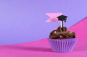 Graduation day pink and purple party cupcake with copy space.