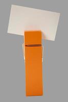 orange clothes pin holding a note with gray background