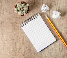Blank notepad with pencil on wooden table photo