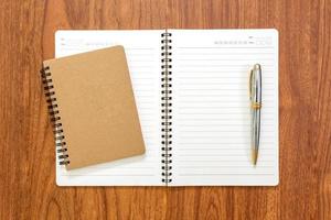 Blank notebook with a pen on wood background photo