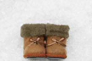 Felt booties on snowy surface with copy space