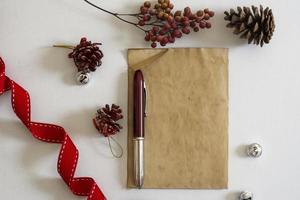 papel viejo, cinta roja y adornos navideños foto