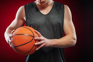 Young male basketball player gripping the ball photo