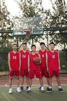 equipo de baloncesto de pie y sonriente, retrato foto