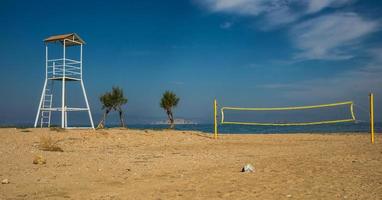 Torre de voleibol y red en la playa de arena