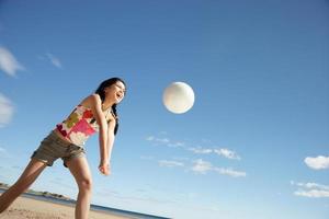 Teenage girl playing beach volleyball photo