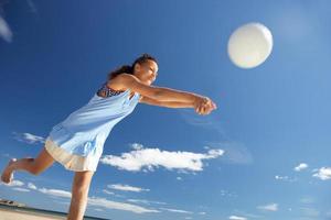 Teenage girl playing beach volleyball photo