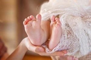 Baby feet in mother hands. Mom and her Child.