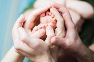 Baby feet on parents hands photo