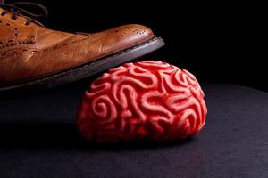 human brain under a business man feet photo