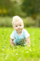 Cute little baby in summer  park on the grass. photo