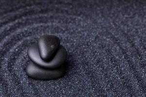 equilibrar piedras de masaje negro en un relajante jardín zen foto