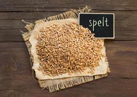 Whole unpolished spelt in a with a small chalkboard