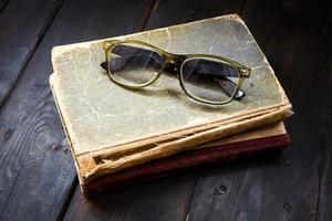 gafas de lectura vintage en la pila de libros foto