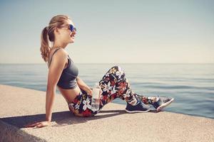 Young fitness blonde woman hold bottle after fit at beach photo