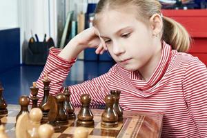 Girl thinking in chess game