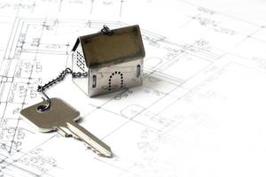 small house model with a house key on architectural drawing photo