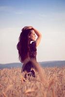 Beautiful girl in wheat field at sunset