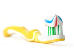 un cepillo de dientes amarillo con un chorro de pasta dental foto