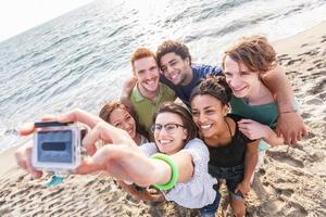 Grupo multirracial de amigos tomando selfie en la playa