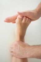 Close up of physiotherapist treating patients foot photo