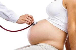 Pregnant woman with doctor isolated on white