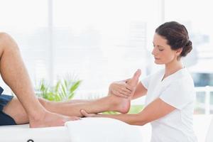 fisioterapeuta haciendo masaje de piernas foto