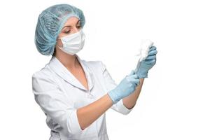 Retrato de mujer cirujano sosteniendo un instrumento quirúrgico sobre fondo blanco.